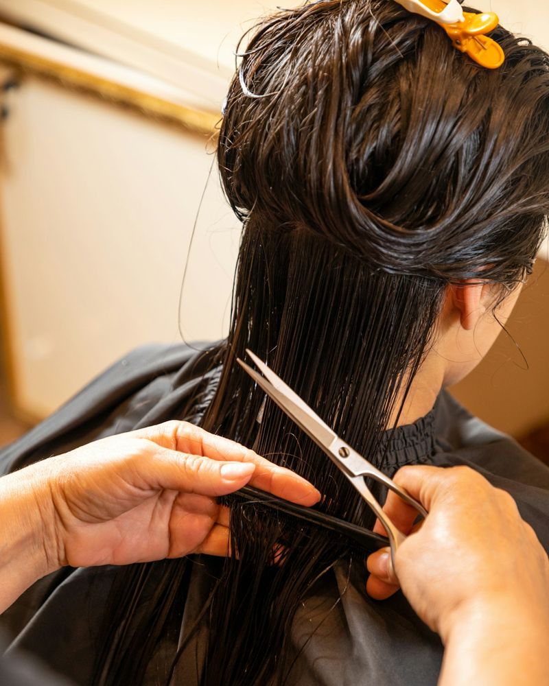 Hairdresser cutting hair with scissors